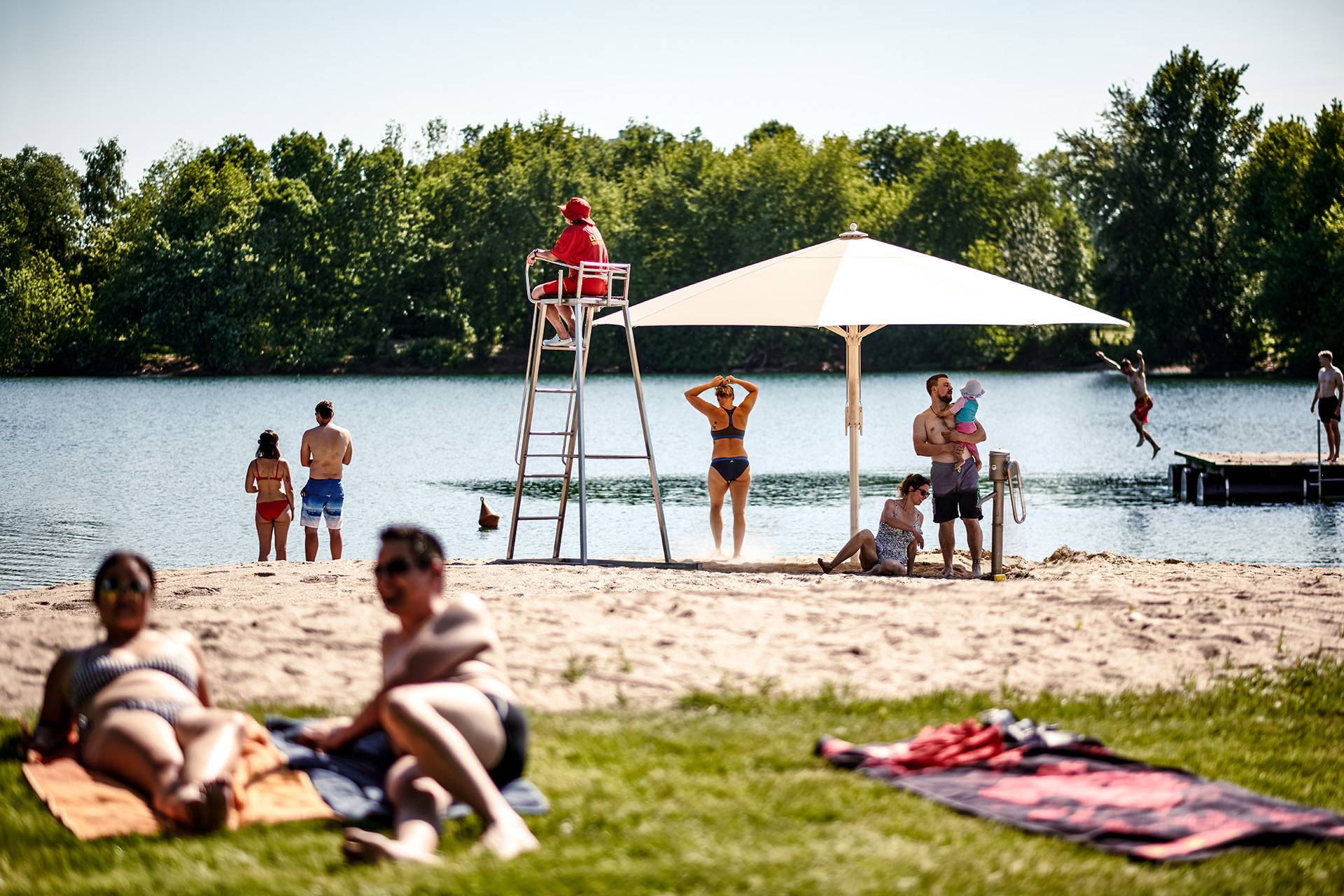 Strandbad, Menschen im Sand und auf der Wiese