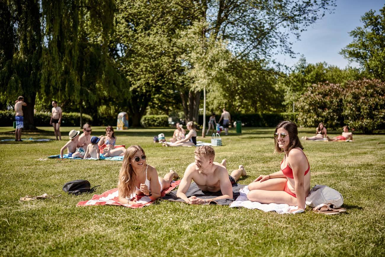 Leute liegen auf ihren Handtüchern im Strandbad