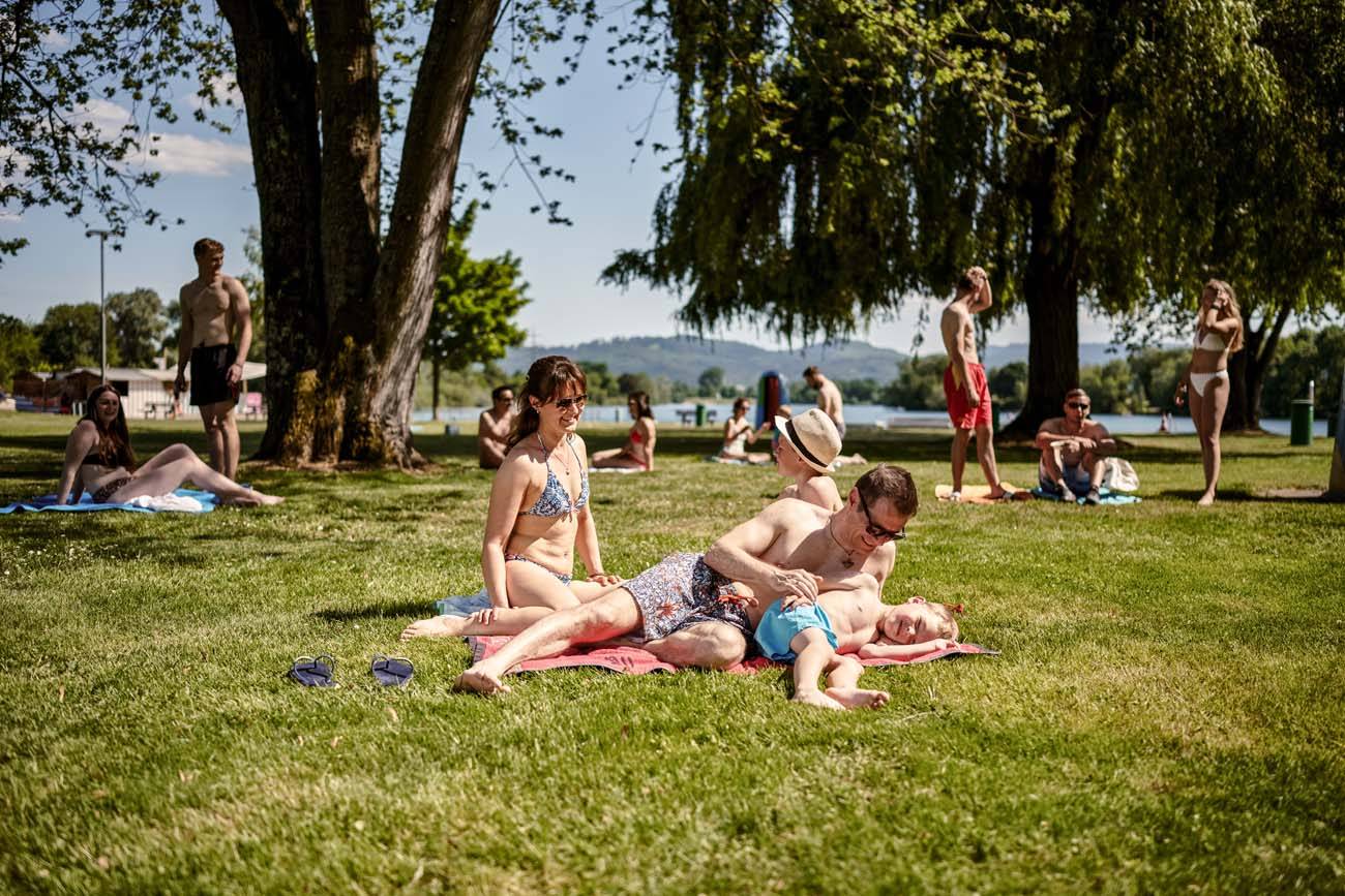 Parents with child lying on a towel on the grass